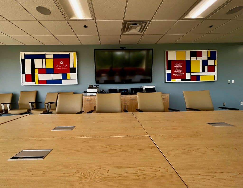 An empty modern boardroom with a screen and seating, used for financial services meetings